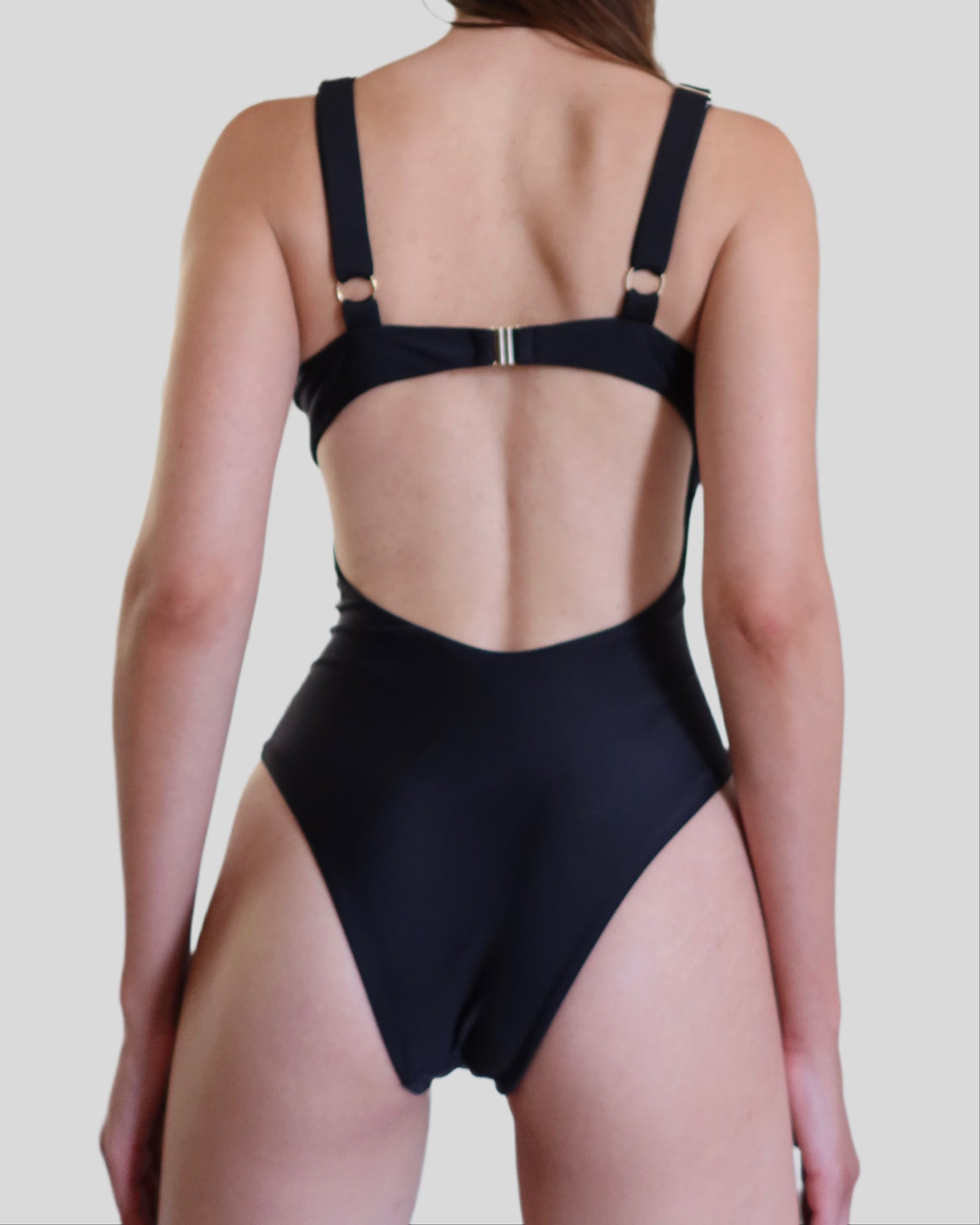 Black luxury one-piece swimwear for women made in Italy with gold accessories in recycled lycra econyl