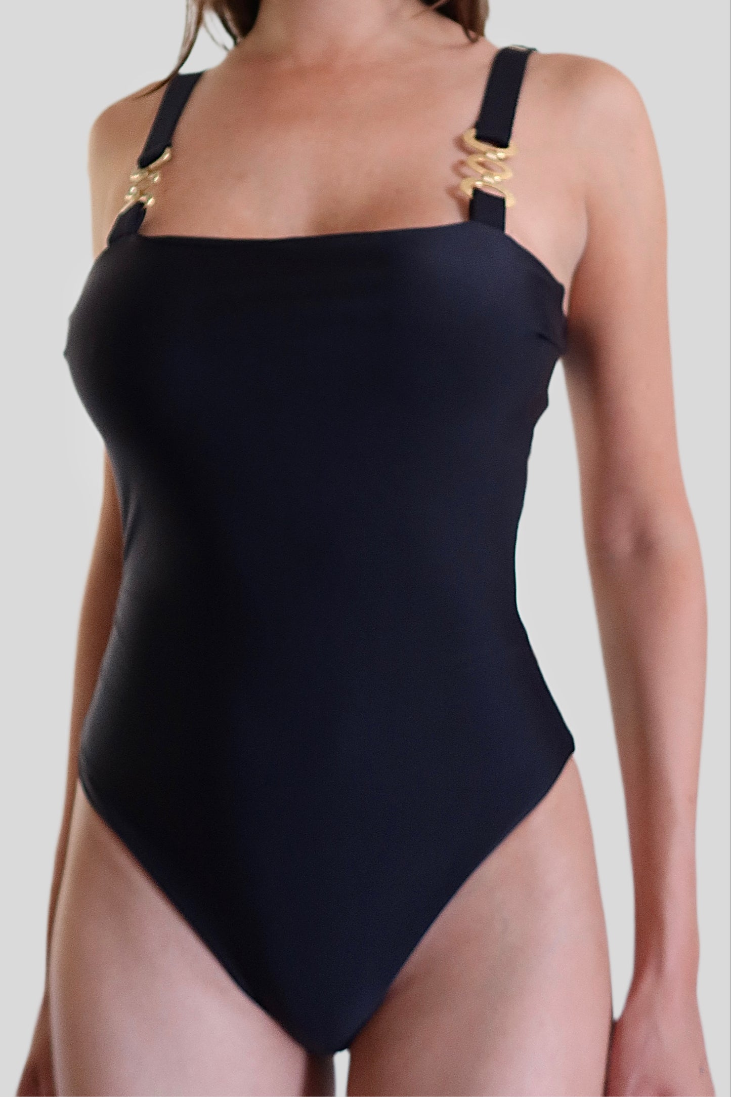 Black luxury one-piece swimwear for women made in Italy with gold accessories in recycled lycra econyl